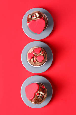 Tasty chocolate cupcakes for Valentine's Day on red backgroundの写真素材