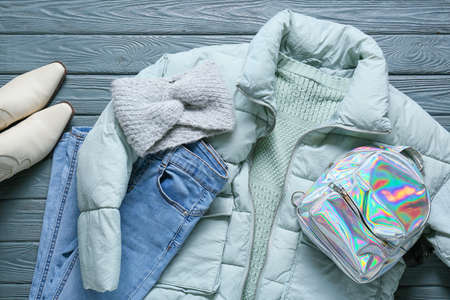 Stylish female jacket, backpack and jeans on gray wooden backgroundの写真素材