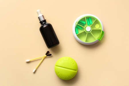Bottle, cotton swabs with iodine and containers with pills on beige background