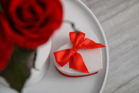 Gift and rose flowers for Valentine's Day on table in room, top viewの写真素材