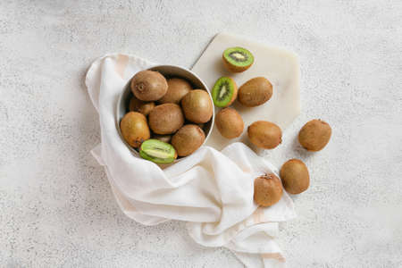 Bowl with fresh ripe kiwi on light backgroundの写真素材