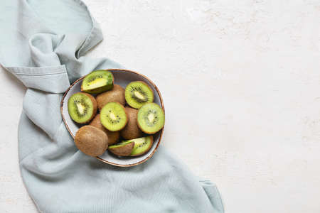 Bowl with fresh cut kiwi on light backgroundの写真素材