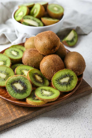 Plate with fresh cut kiwi on light background, closeupの写真素材