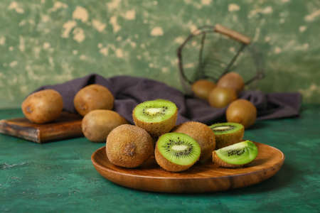 Plate with fresh ripe kiwi on green background, closeupの写真素材