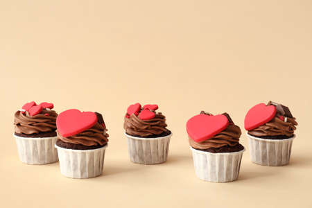 Tasty chocolate cupcakes for Valentine's Day on beige backgroundの写真素材