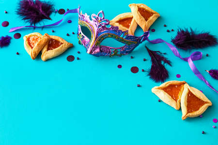 Carnival mask and Hamantaschen cookies for Purim holiday on color backgroundの写真素材