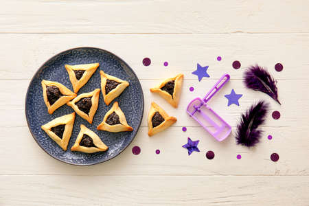 Hamantaschen cookies and rattle for Purim holiday on white wooden backgroundの写真素材