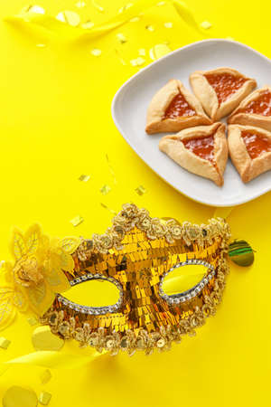 Carnival mask and Hamantaschen cookies for Purim holiday on color backgroundの写真素材