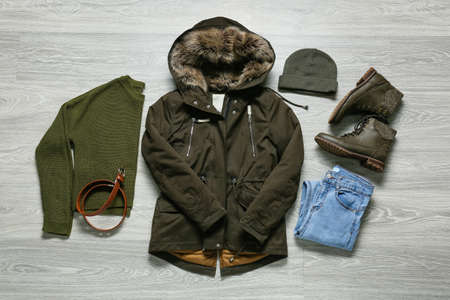 Jacket, pants, sweater, hat, shoes and belt on gray wooden backgroundの写真素材