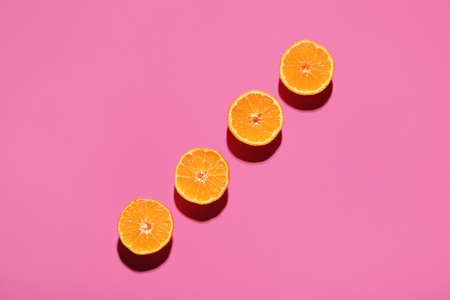 Cut juicy tangerines on color backgroundの写真素材