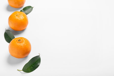 Sweet tangerines and leaves on white background