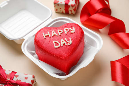 Plastic lunch box with tasty bento cake for Valentine's Day on beige backgroundの写真素材