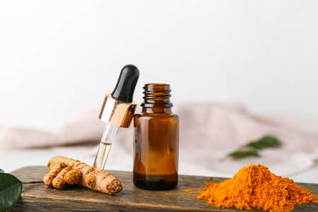 Bottle of oil, turmeric root and powder on light backgroundの写真素材