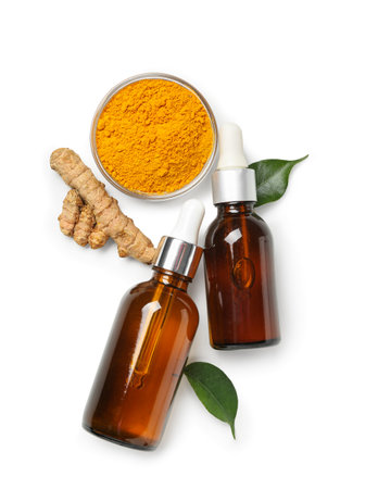Bottles of oil, turmeric root and bowl with powder on white backgroundの写真素材