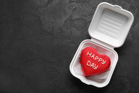 Plastic lunch box with tasty bento cake on dark backgroundの写真素材