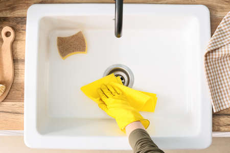 Woman wiping ceramic sink, closeupの写真素材
