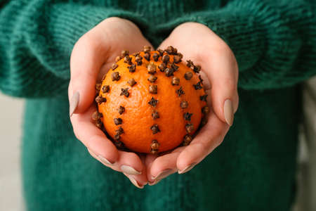 Woman holding handmade Christmas decoration made of tangerine with cloves, closeupの写真素材