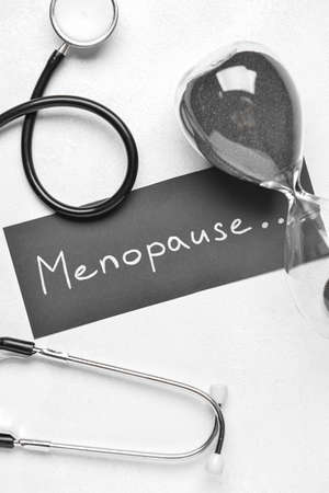 Paper with word MENOPAUSE, hourglass and stethoscope on white backgroundの写真素材