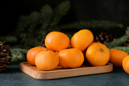 Wooden board with tangerines on dark backgroundの写真素材