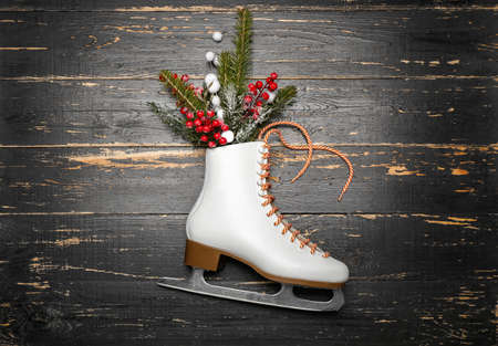 Ice skate and fir branch on dark wooden backgroundの写真素材