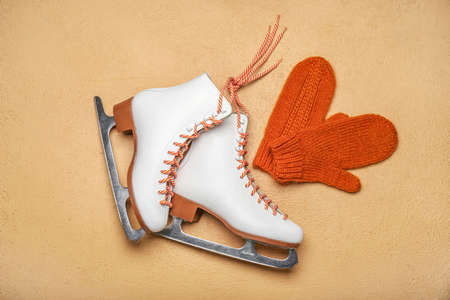 Ice skates and mittens on beige backgroundの写真素材