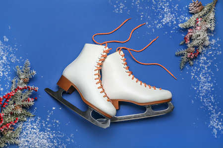 Ice skates and fir branches on blue backgroundの写真素材