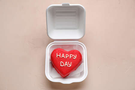 Plastic lunch box with tasty bento cake on beige backgroundの写真素材