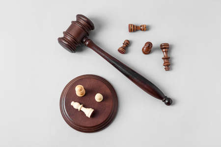 Judge gavel and chess pieces on gray backgroundの写真素材