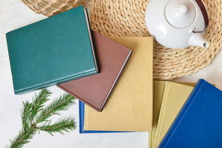 Books, teapot and fir branches on white background