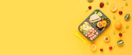 School lunch box with tasty food on color background with space for textの写真素材