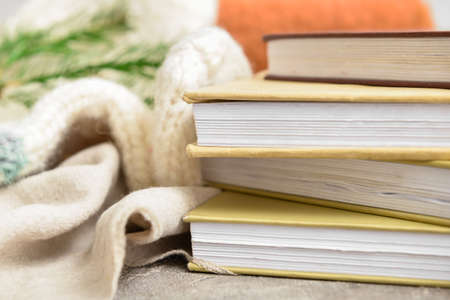 Stack of books, plaid and socks on table, closeup