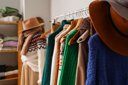 Rack with warm sweaters and hats in dressing room, closeupの写真素材