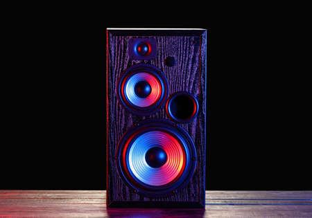 Modern loudspeaker on table against black backgroundの写真素材