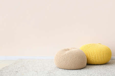 Modern poufs near light wall in roomの写真素材