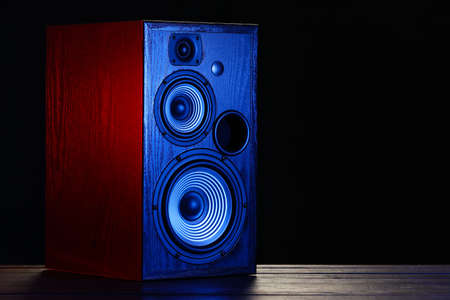 Modern loudspeaker on table against black backgroundの写真素材