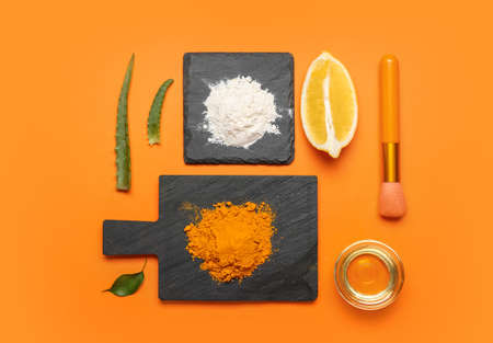 Composition with turmeric mask, powder and oil on orange backgroundの写真素材