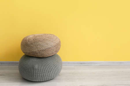 Modern poufs near color wall in roomの写真素材