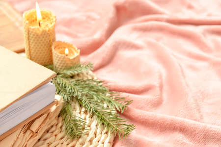 Closeup view of books, fir tree branch and burning candles on bedの写真素材