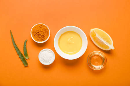 Composition with turmeric mask, powder and oil on orange backgroundの写真素材