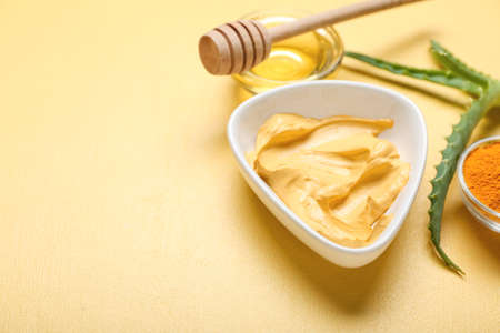 Bowl with turmeric mask, powder and honey on beige background, closeupの写真素材
