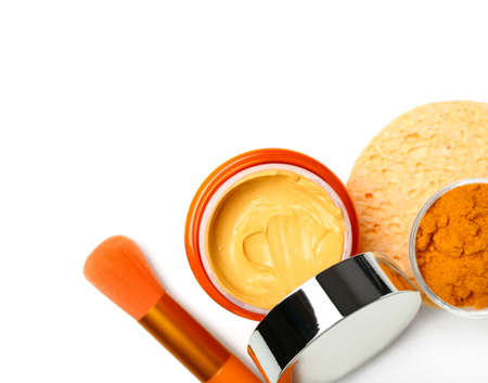 Jar with turmeric mask, powder and makeup brush on white backgroundの写真素材