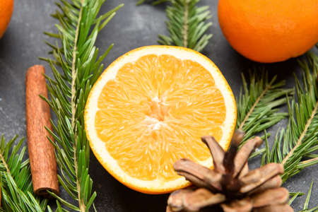 Half of fresh orange and fir branches on black backgroundの写真素材