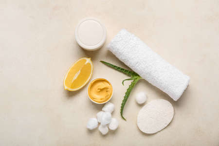 Bowl with turmeric mask, lemon and cotton balls on light backgroundの写真素材