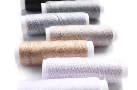 Multicolored sewing thread spools on white background