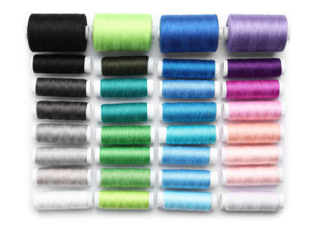 Multicolored sewing thread spools on white background