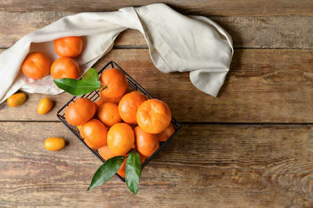 Basket with juicy citrus fruits on wooden backgroundの写真素材