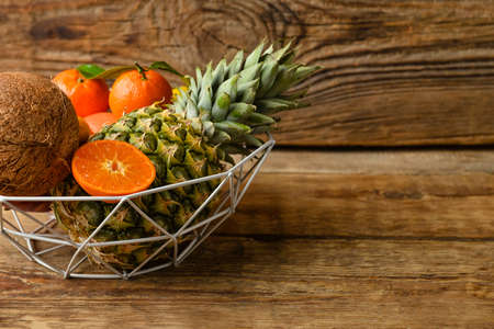 Basket with juicy fruits on wooden background, closeupの写真素材