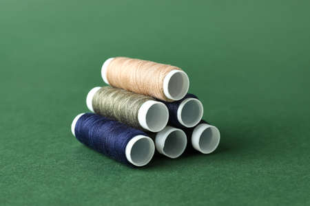 Multicolored sewing thread spools on color background