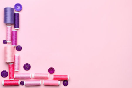 Sewing thread spools and buttons on color backgroundの写真素材