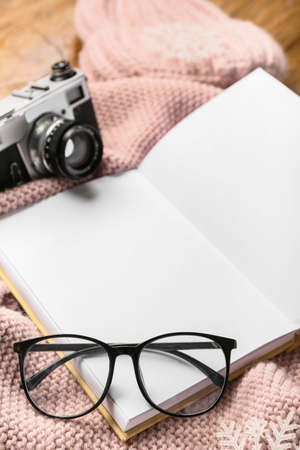 Eyeglasses and opened book with blank pages on winter clothes, closeupの写真素材